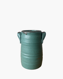 Green ceramic vase with ear-like handles on a white background