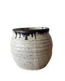 A beige and bronze ceramic utensil crock or vase on a white background. 
