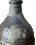 Stoneware bottle with a textured surface on a white background