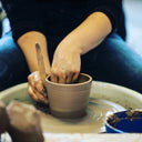 Person throwing a pottery cup
