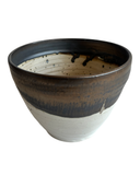 Ceramic bowl with a black and white speckled design on a white background