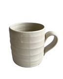 Beige ceramic mug on a white background