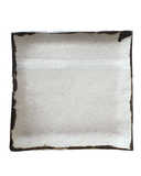 Square ceramic plate with black rim on a white background