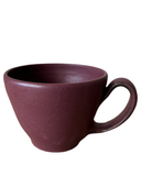 A beige speckled stoneware cappuccino mug with a bronze accented handle and matte glaze.