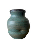 A teal and bronze vase on a white background. The vase has a thumprint. 