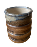 Ceramic pot with ribbed texture and gradient color on a white background
