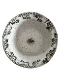 Ceramic bowl with speckled design on a white background